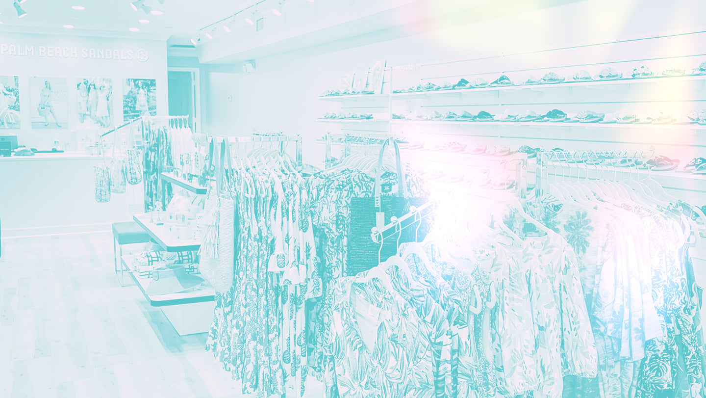 The Palm Beach Sandals Boutique Vero Beach location. Photo features a beachy washed out style with light leaks. Dresses are in the foreground with sandals, bags, and accessories behind.